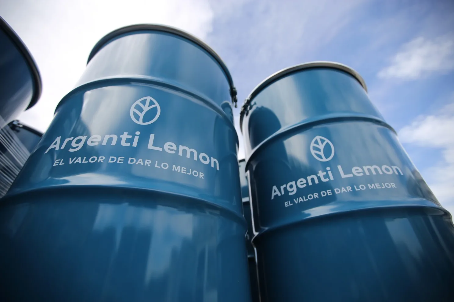 Argenti Lemon branded drums with the slogan, photographed against the sky.